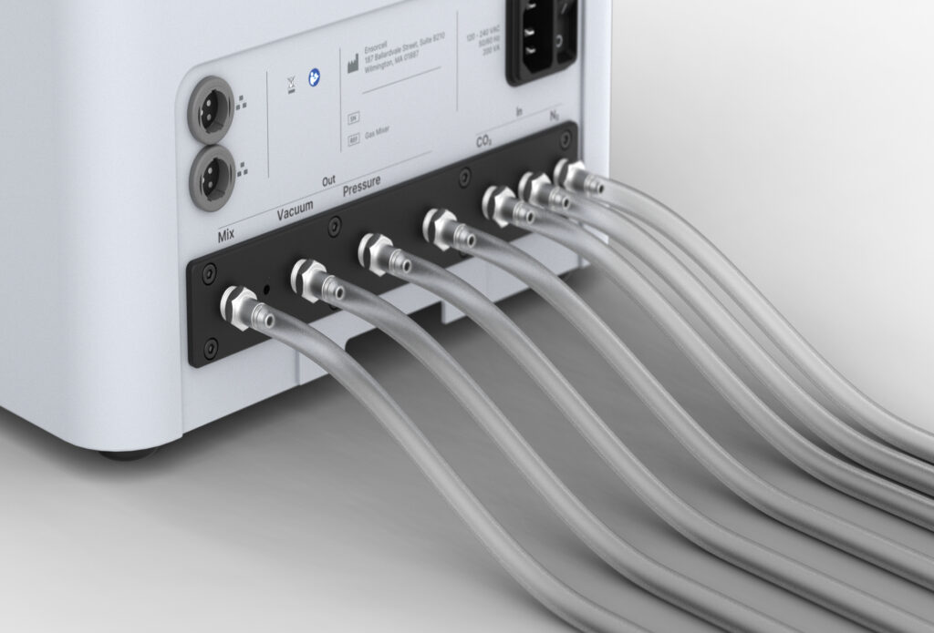 A Ensorcell Premaerix laboratory gas mixer with connected tubing for precise gas mixing equipment used in medical lab instruments and research applications sits atop a gray background.