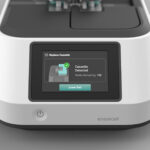 An Ensorcell Versaweld sterile tube welder with touchscreen display showing cassette detection status for bioprocessing and aseptic tube welding applications sits atop a dark gray background.