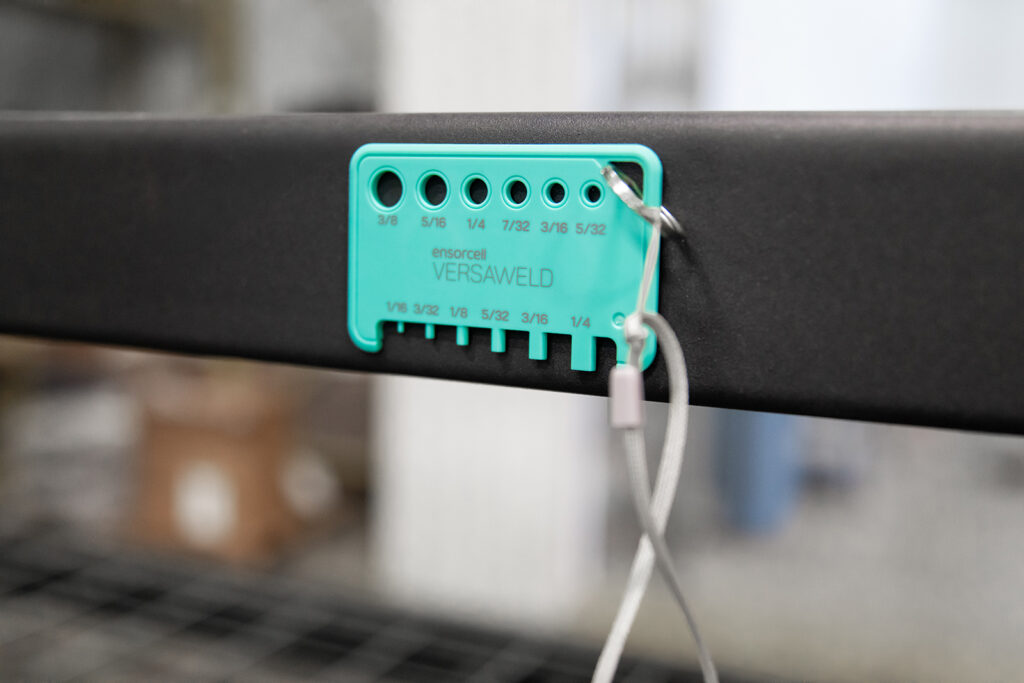 The tube gauge is shown magnetically attached to a metal shelf, demonstrating that it can securely stick to metal surfaces.