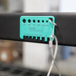 The tube gauge is shown magnetically attached to a metal shelf, demonstrating that it can securely stick to metal surfaces.
